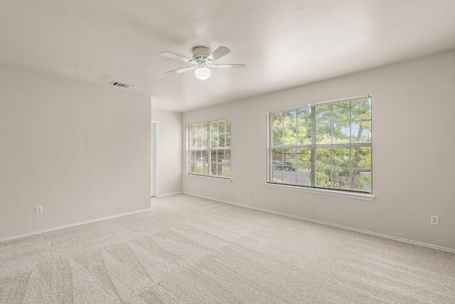 spare room with light carpet, a textured ceiling, and ceiling fan