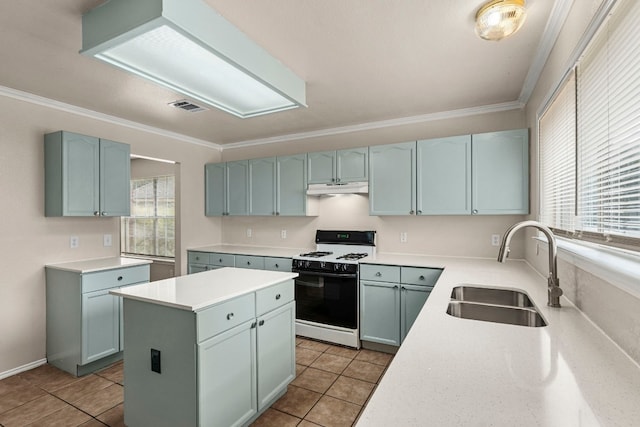 kitchen with white gas stove, light tile patterned floors, a wealth of natural light, and sink