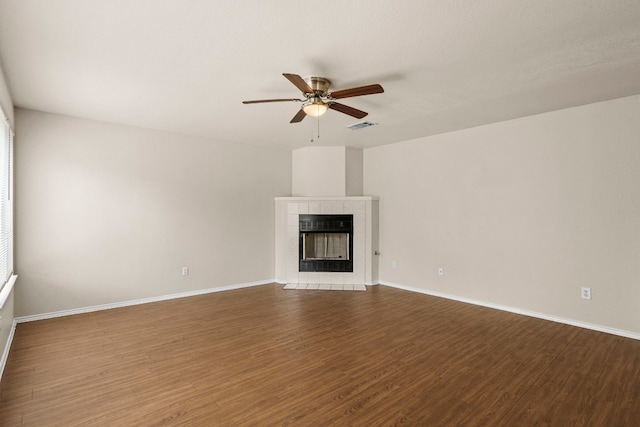 unfurnished living room featuring hardwood / wood-style floors, ceiling fan, and a tile fireplace