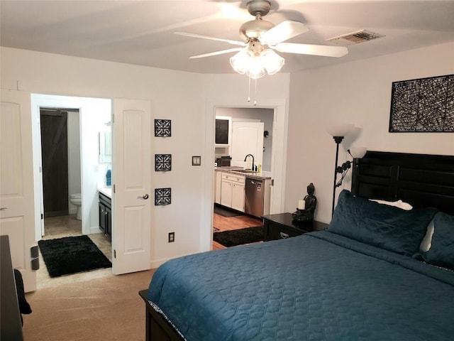 carpeted bedroom with ensuite bathroom, ceiling fan, and sink