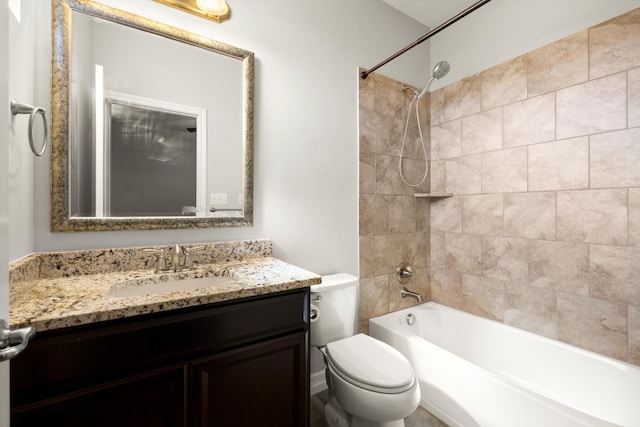 full bathroom featuring tiled shower / bath, toilet, and vanity