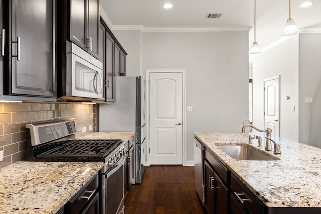 kitchen featuring stainless steel appliances, dark hardwood / wood-style flooring, sink, pendant lighting, and ornamental molding