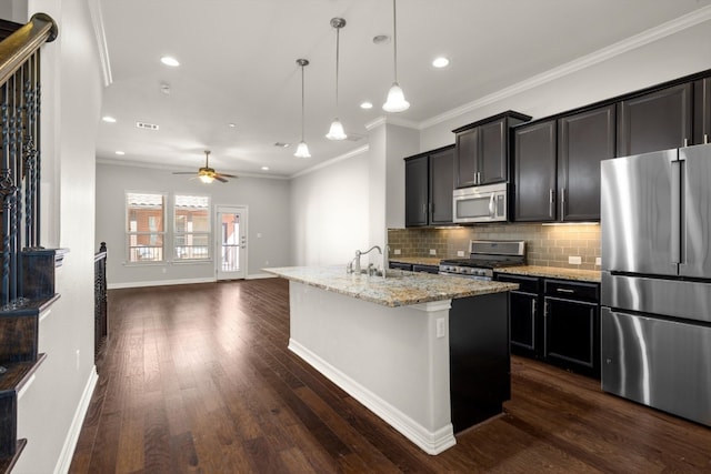 kitchen with dark hardwood / wood-style flooring, appliances with stainless steel finishes, a kitchen island with sink, ceiling fan, and light stone counters