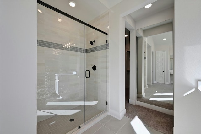 bathroom with tile patterned floors, an enclosed shower, and an inviting chandelier