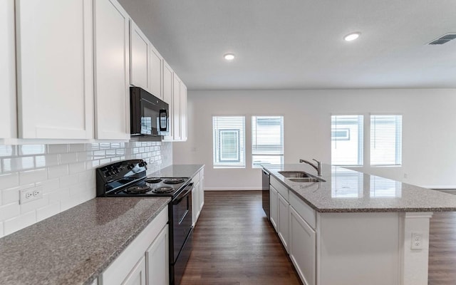 kitchen with sink, tasteful backsplash, a kitchen island with sink, white cabinets, and black appliances