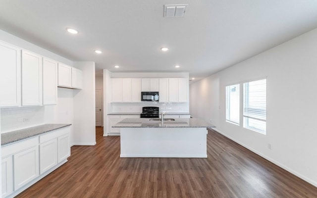 kitchen with white cabinets, sink, a center island with sink, and black appliances