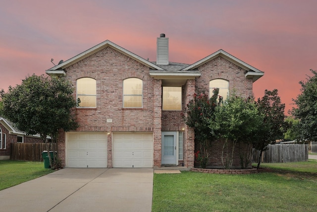 view of front of property featuring a garage and a lawn