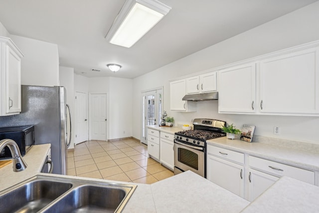 kitchen featuring white cabinets, light tile patterned floors, stainless steel range with gas cooktop, and sink