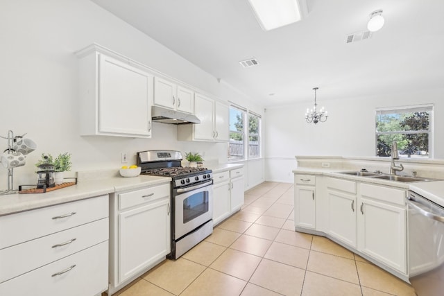 kitchen featuring light tile patterned flooring, white cabinets, pendant lighting, stainless steel appliances, and sink