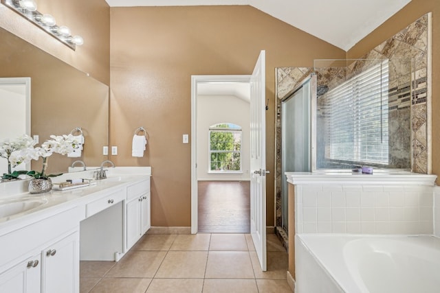 bathroom featuring shower with separate bathtub, lofted ceiling, vanity, and tile patterned flooring