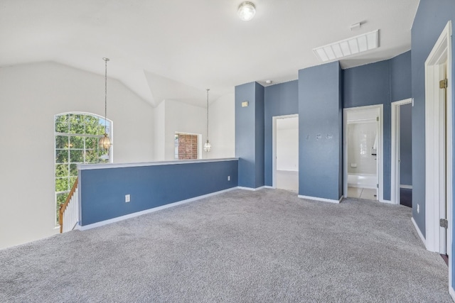 carpeted empty room with a notable chandelier and lofted ceiling