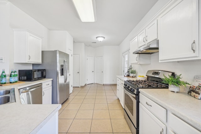 kitchen with white cabinets, appliances with stainless steel finishes, and light tile patterned flooring