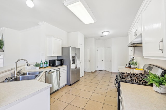 kitchen featuring appliances with stainless steel finishes, white cabinets, light tile patterned floors, crown molding, and sink