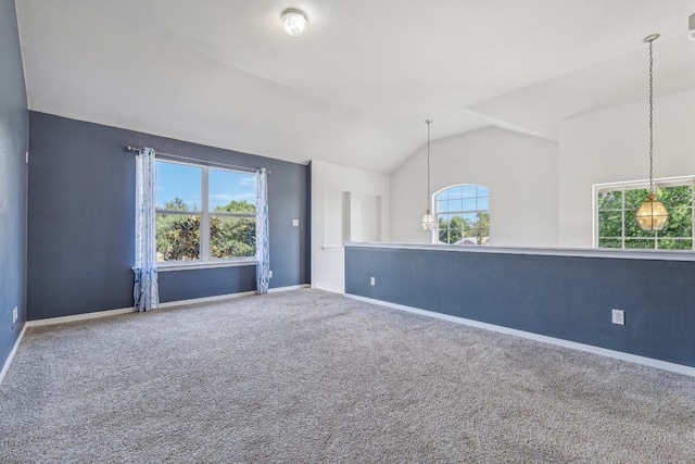 unfurnished room with lofted ceiling, plenty of natural light, carpet flooring, and a chandelier