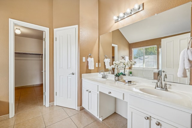 bathroom with lofted ceiling, tile patterned floors, and vanity