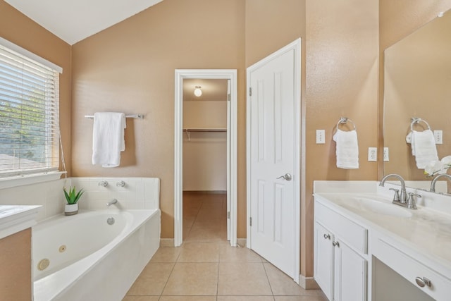 bathroom featuring tile patterned floors, vaulted ceiling, vanity, and a bathtub