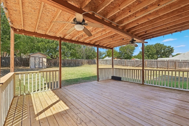 wooden terrace featuring a yard, a storage unit, and ceiling fan