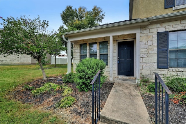 view of exterior entry with a lawn