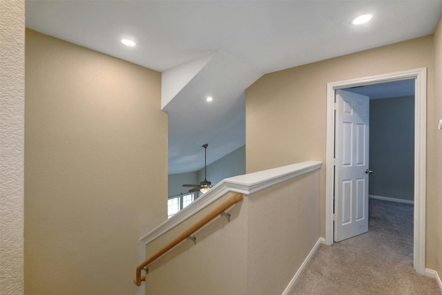 corridor featuring light carpet and vaulted ceiling