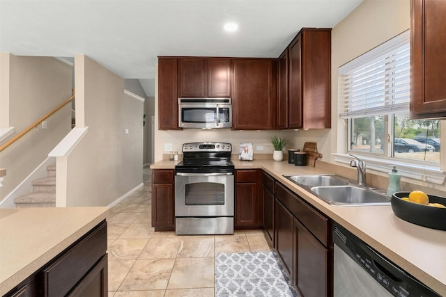 kitchen featuring sink, light tile patterned flooring, and stainless steel appliances