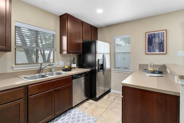 kitchen featuring sink, appliances with stainless steel finishes, dark brown cabinetry, and plenty of natural light