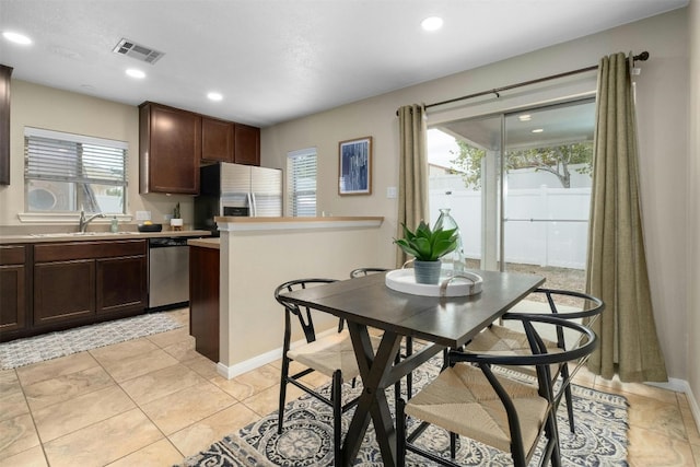 interior space featuring sink, appliances with stainless steel finishes, dark brown cabinetry, and a healthy amount of sunlight