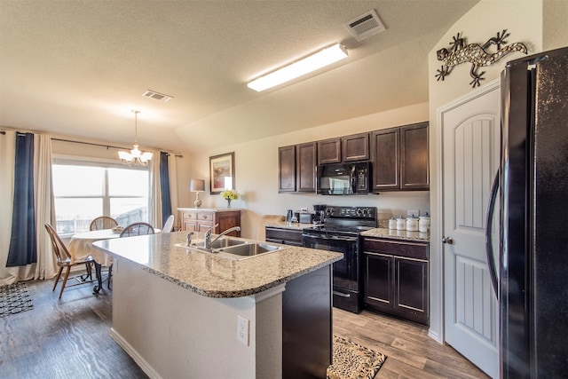 kitchen featuring decorative light fixtures, black appliances, wood-type flooring, sink, and a chandelier