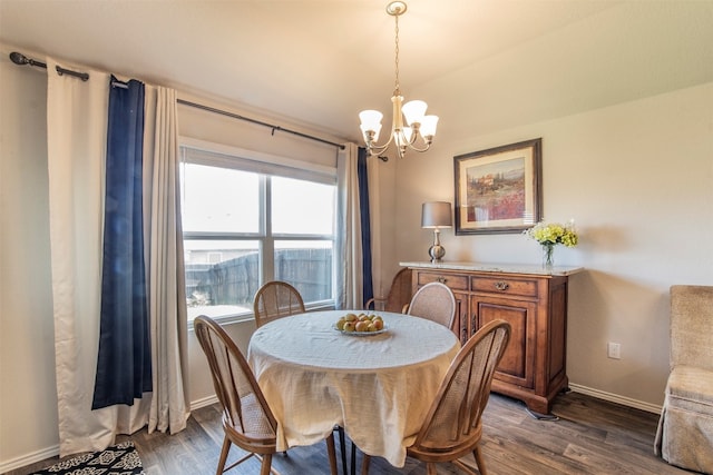 dining space featuring hardwood / wood-style flooring and an inviting chandelier