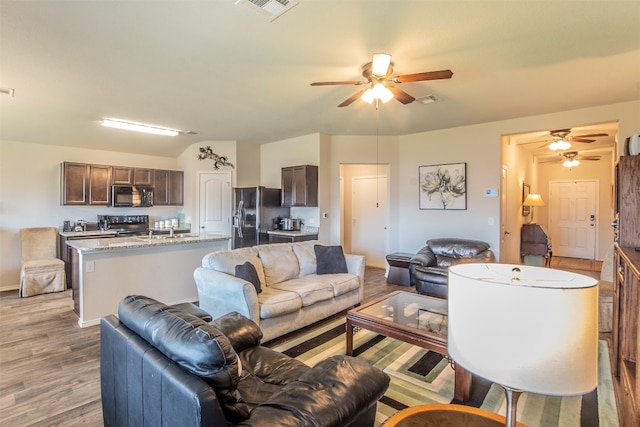 living room featuring ceiling fan and wood-type flooring