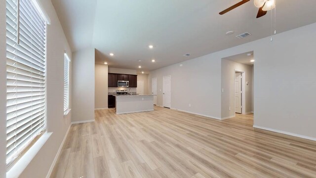 unfurnished living room with light hardwood / wood-style flooring and ceiling fan