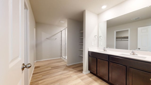 bathroom with a shower with door, hardwood / wood-style flooring, and vanity