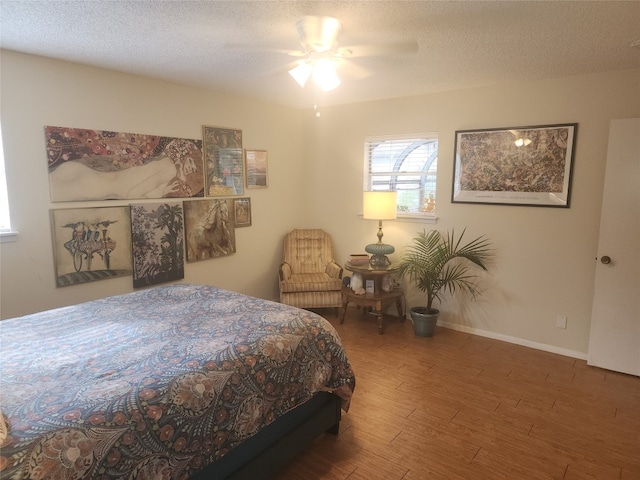 bedroom featuring a textured ceiling, dark hardwood / wood-style floors, and ceiling fan