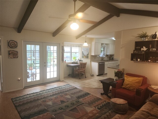 living room featuring ceiling fan, vaulted ceiling with beams, light hardwood / wood-style flooring, french doors, and sink