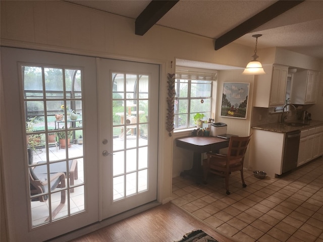 entryway with sink, light tile patterned flooring, beamed ceiling, and a wealth of natural light