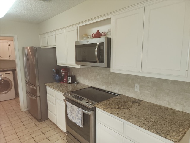 kitchen featuring washer / dryer, tasteful backsplash, stone countertops, white cabinetry, and stainless steel appliances