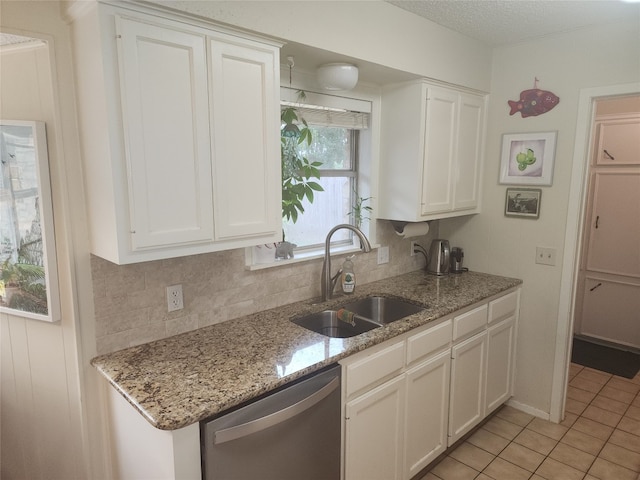 kitchen featuring white cabinets, backsplash, light stone countertops, stainless steel dishwasher, and sink