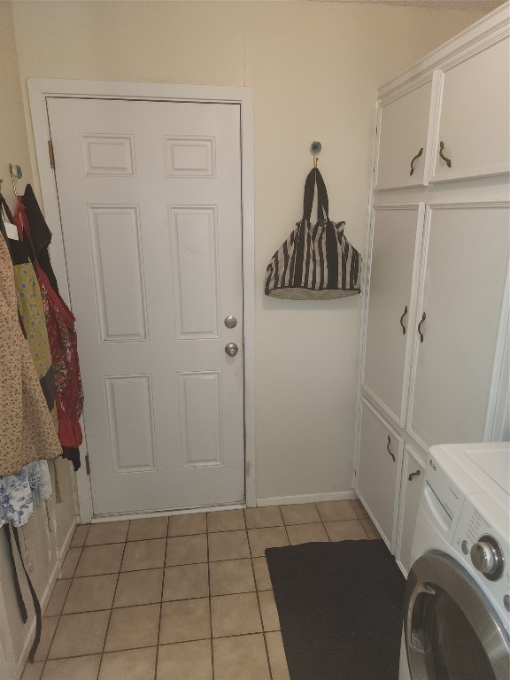 clothes washing area with cabinets, washer / clothes dryer, and light tile patterned flooring