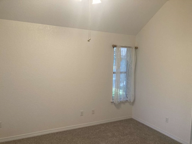 carpeted empty room with vaulted ceiling