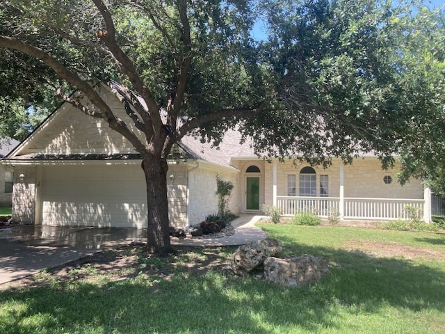 view of front of house with a garage, covered porch, and a front yard