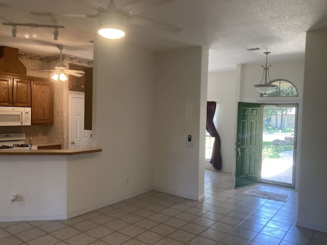 kitchen with white appliances, light tile patterned flooring, ceiling fan, and a textured ceiling