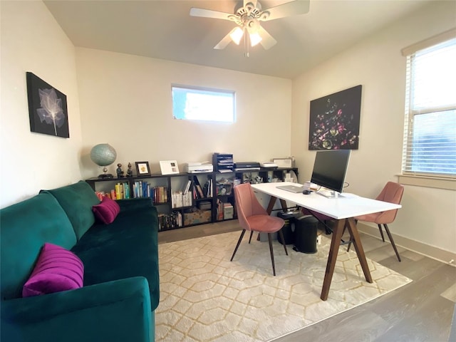 home office with light hardwood / wood-style floors and ceiling fan