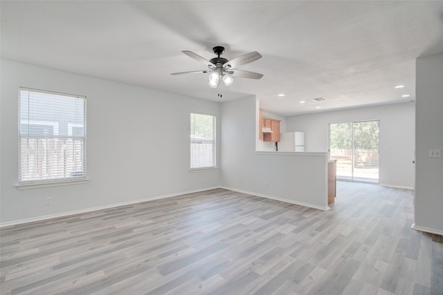 interior space with light wood-type flooring, ceiling fan, and a wealth of natural light