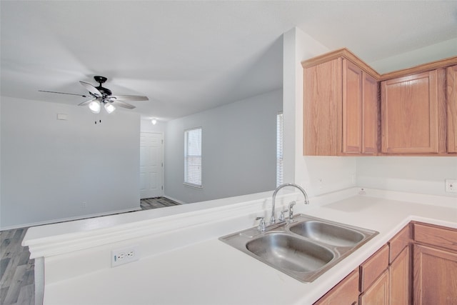 kitchen featuring hardwood / wood-style floors, ceiling fan, kitchen peninsula, and sink