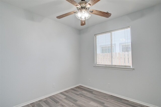 empty room with ceiling fan and hardwood / wood-style flooring