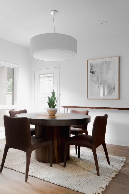 dining area featuring a wealth of natural light, baseboards, and wood finished floors