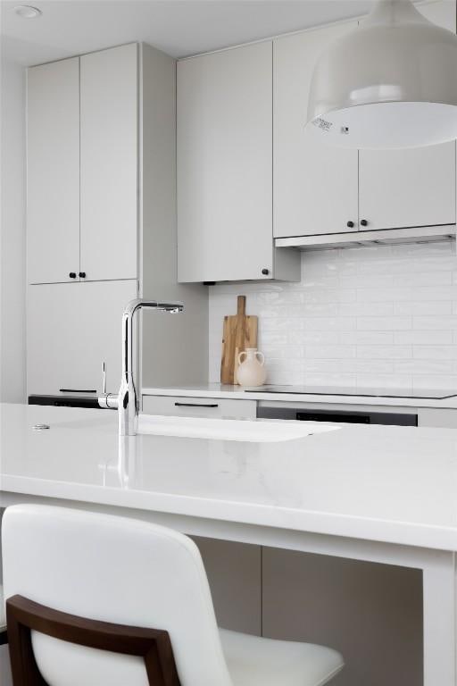 kitchen featuring light countertops, backsplash, and white cabinets