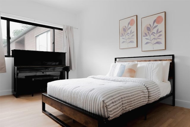 bedroom with light wood-style flooring and baseboards