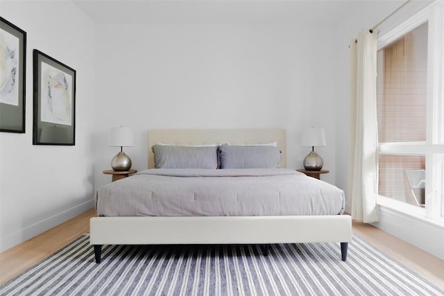 bedroom featuring wood finished floors and baseboards