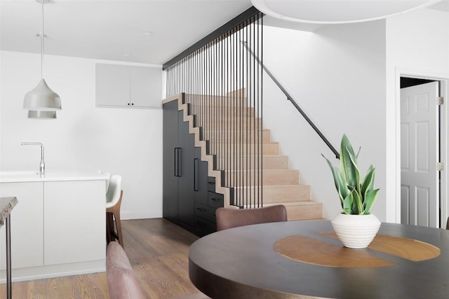 dining room featuring light wood finished floors and stairway