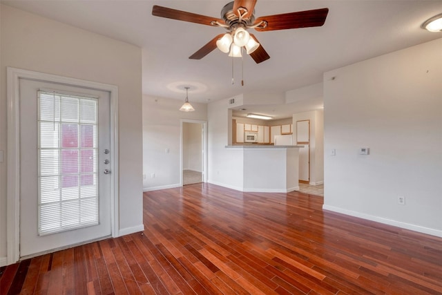 unfurnished living room with ceiling fan and hardwood / wood-style flooring